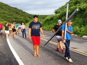 Agricultor paga promessa carregando cruz após cheia da barragem de Quixeramobim