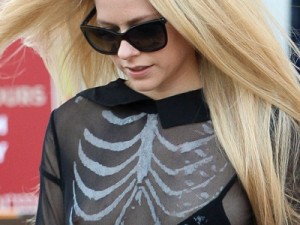 Avril Lavigne se descuida e deixa mamilo à mostra durante passeio