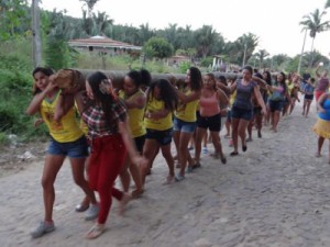 Mulheres carregam e hasteiam o pau da bandeira de São João no Sítio Correntinho