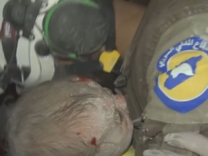 Voluntário chora após resgatar bebê de escombros na Síria