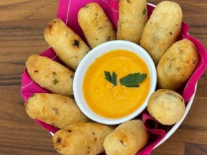 Bolinho caipira recheado de linguiça e que leva um molho especial de cenoura e tomate